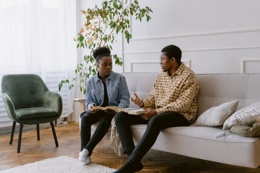 Two adults engaging in a thoughtful conversation in a cozy living room setting.